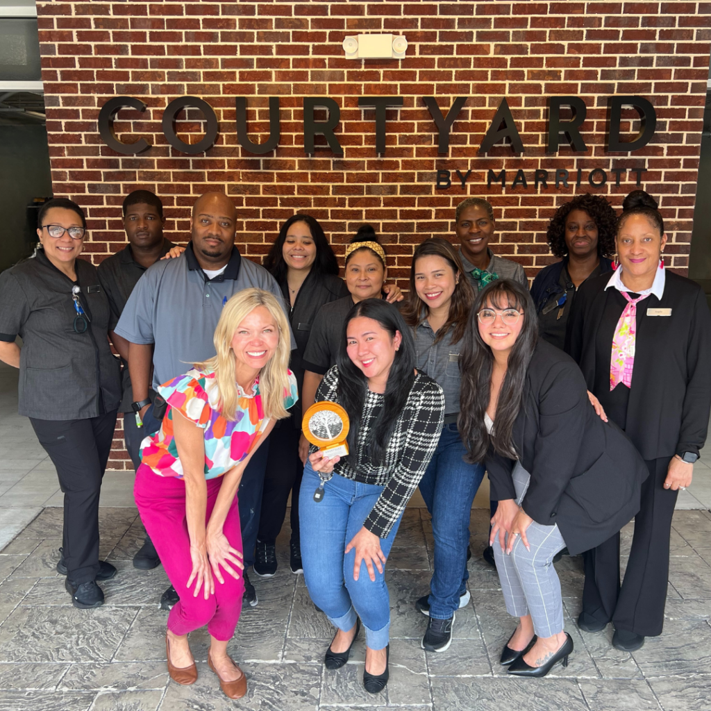 The hotel team at the Courtyard Atlanta Duluth Downtown, all gathered around their Platinum Circle Award from Marriott Select Brands. 