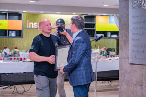 LBA Hospitality President Beau Benton presents a recognition plaque during the 79th Band of Brothers reunion at Home2 Suites Fayetteville Fort Liberty.